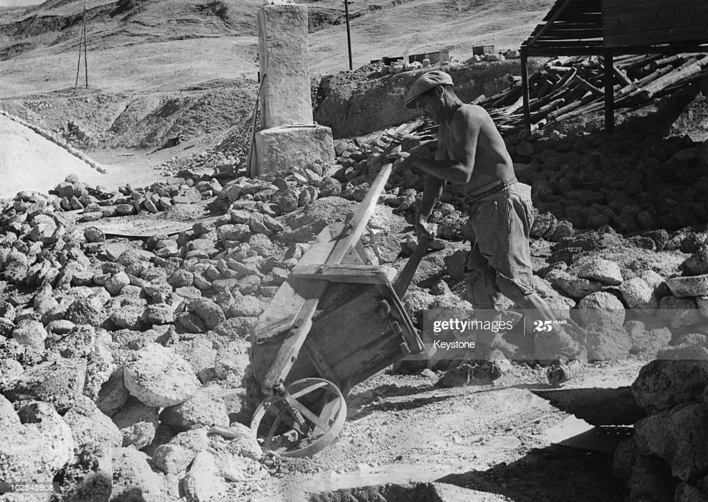 Black and white photo of a man working in a sulfur mine. 