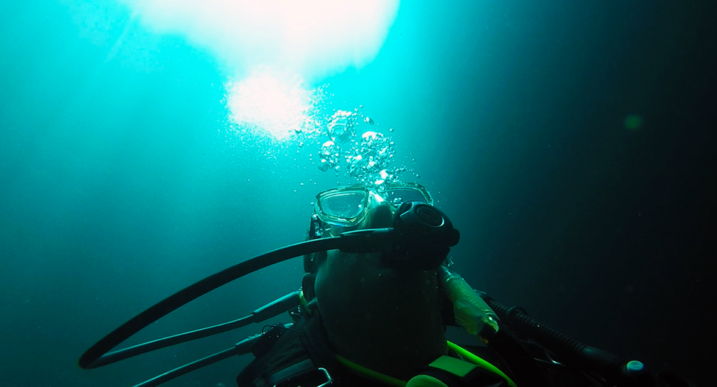 Image of a diver rising toward the light, with bubbles.